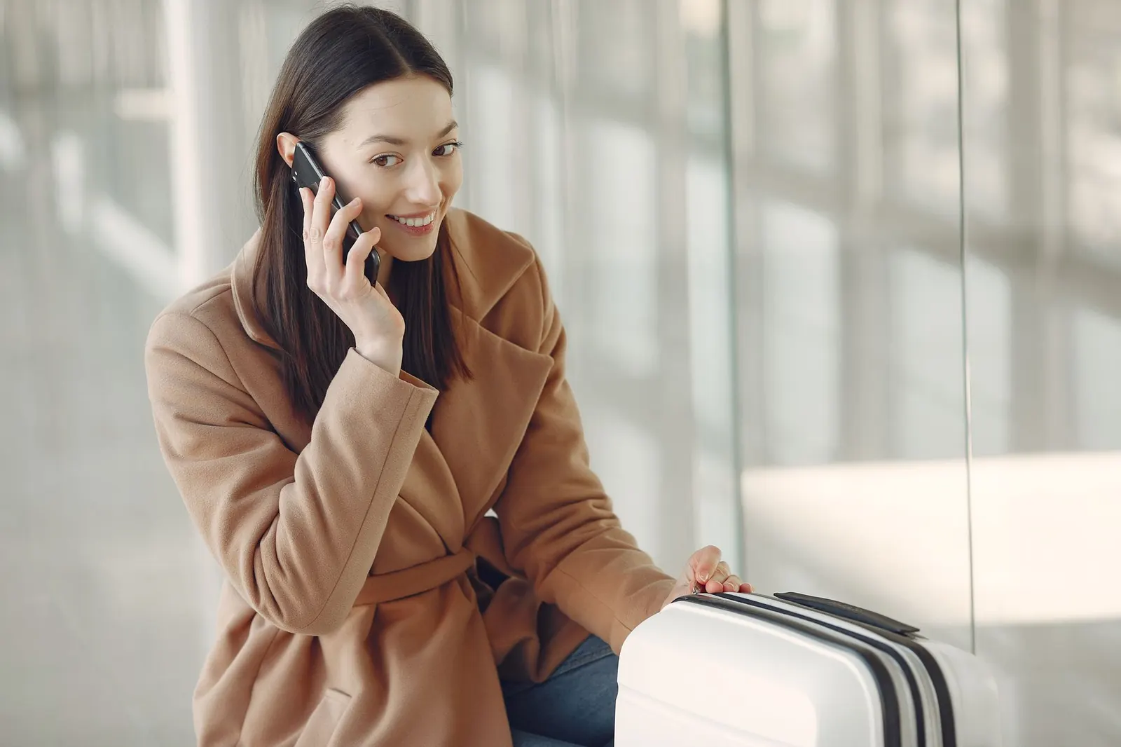 Utazó a reptéri váróban a telefonján ellenőrzi a jóváhagyást