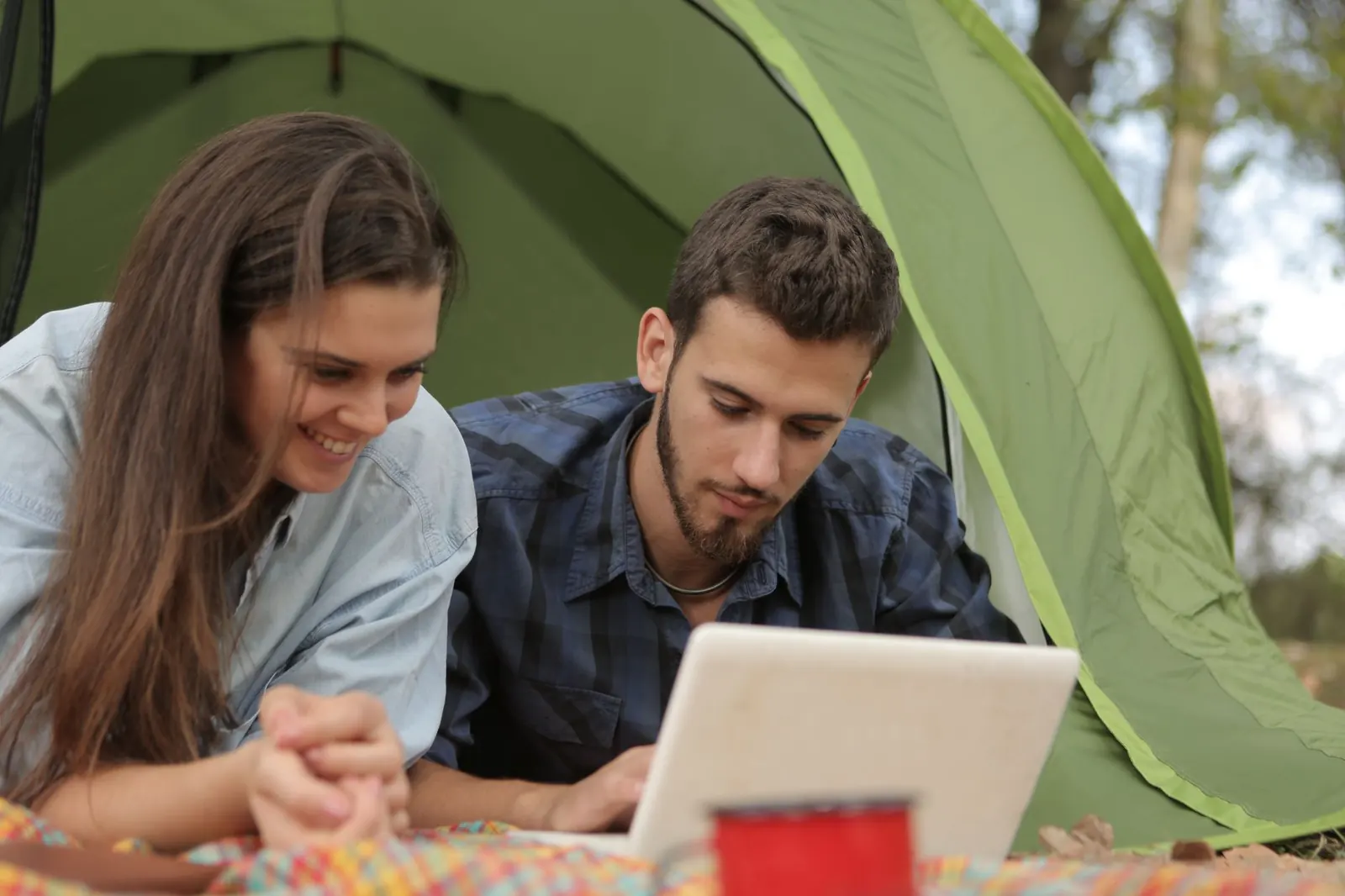 Pár last minute utat foglal a laptopnál otthon a nappaliban