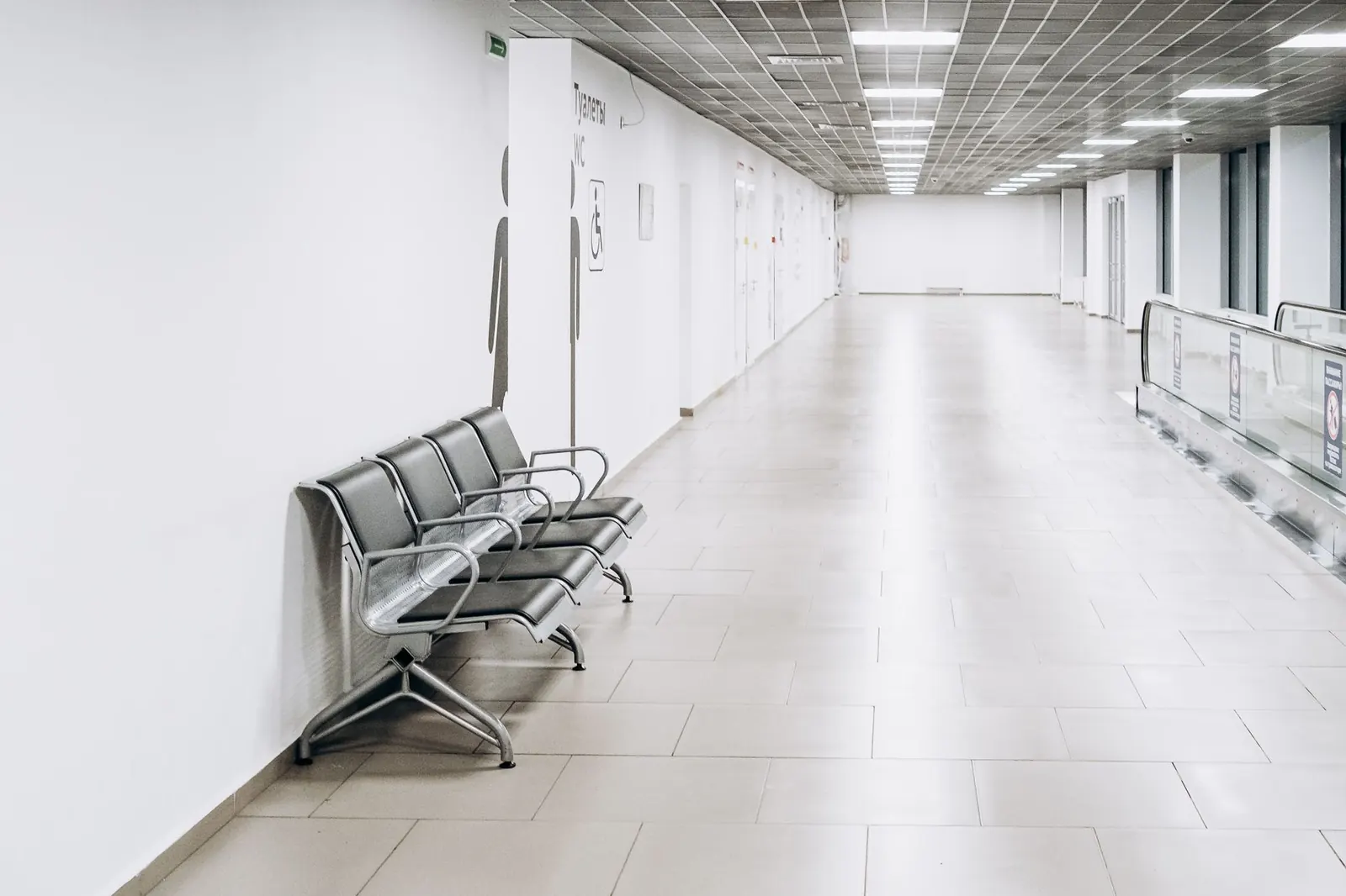 Üres, világos repülőtéri terminálcsarnok mennyezeti lámpákkal