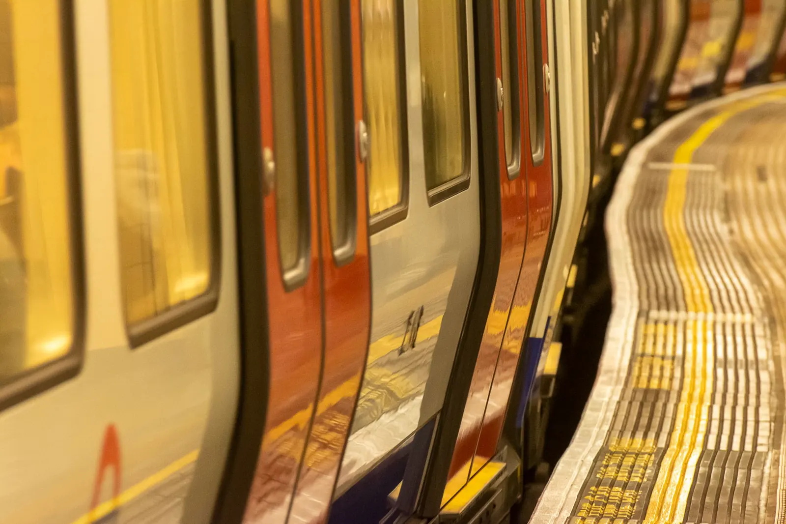 Kanyarodó londoni metróperon beérkező szerelvénnyel